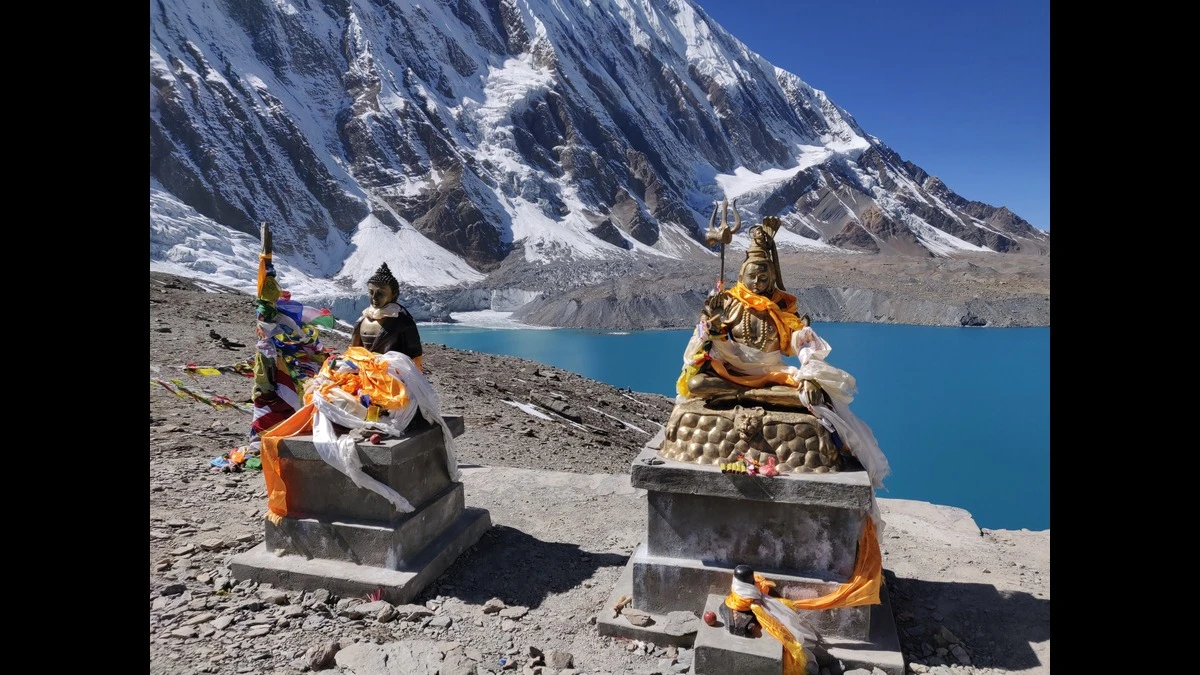 Buddha and Shiva statues in front of glacier lake on the Annapurna Circuit Trek in Nepal