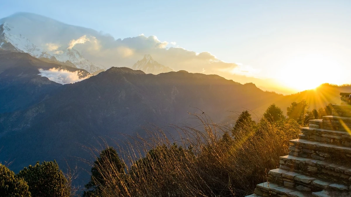 Stone trail leading through green mountains under sunset skies and clouds in Annapurna Massif