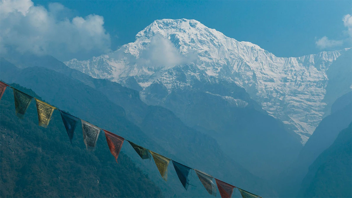 Crystal-clear reflection of the Himalayas with colorful prayer flags in Annapurna Sanctuary