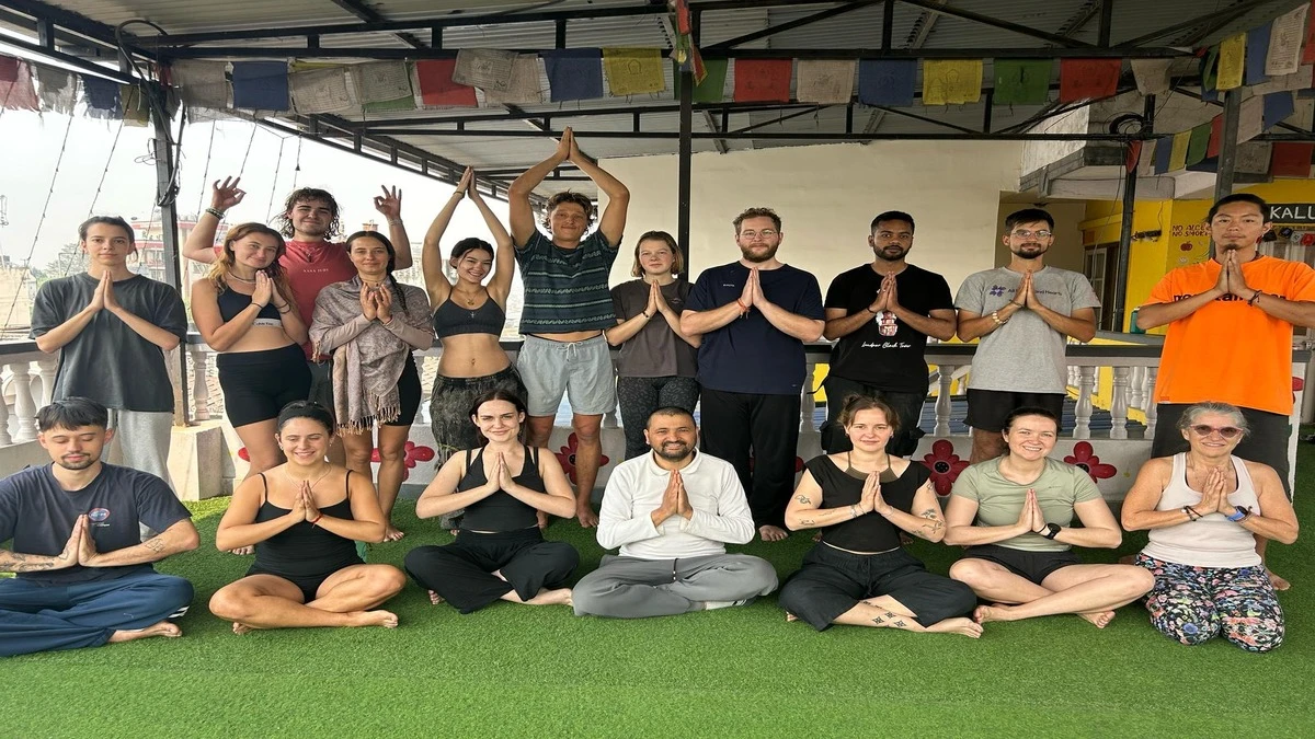 Trekkers in deep meditation, practicing Namaskar with smiles, guided by their yoga guru at a Yoga House in Nepal during the Mardi Himal Yoga Trek.