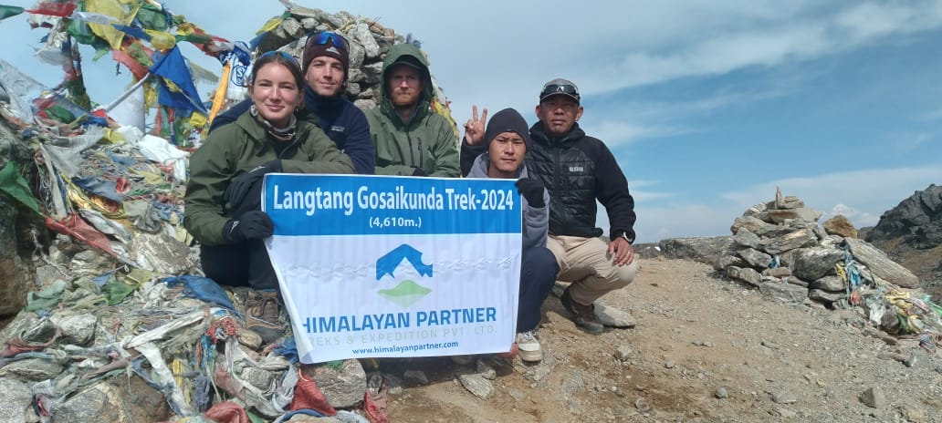 Trekkers, guides, and porters celebrating at Gosaikunda after completing the Langtang Valley trek
