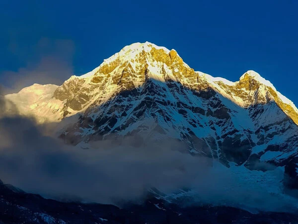 Golden sunlight shines on the Annapurna peaks, showcasing the stunning Annapurna Base Camp via Poon Hill route