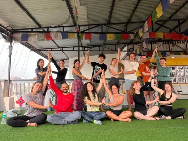 Yoga guru and trekkers doing a yoga pose inside a yoga house on the Mardi Himal Trek in Nepal.